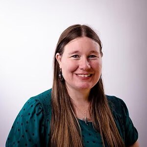 Laura Sass-Germain, smiling, wearing a teal dotted top